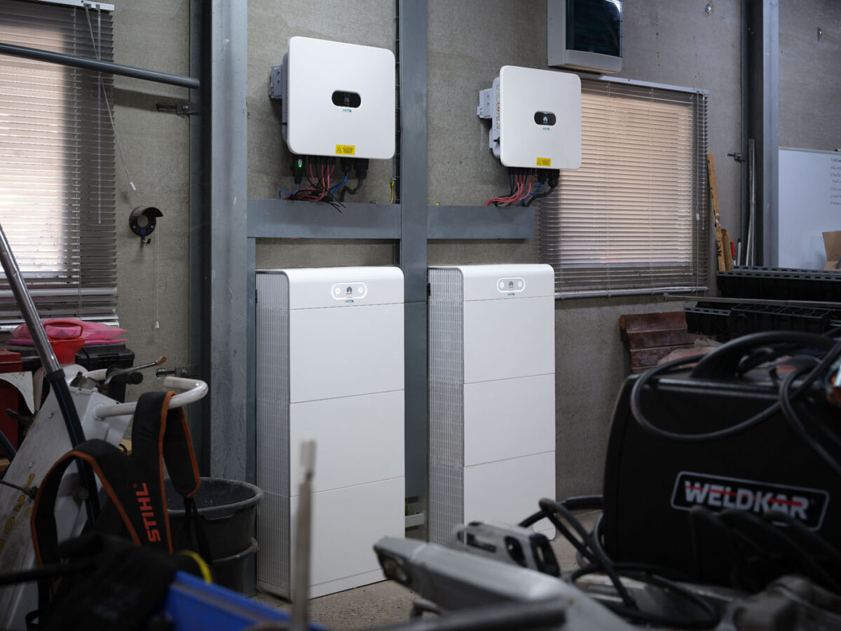 Twee thuisbatterijen met bijbehorende omvormers geïnstalleerd door HETTA energie voor opslag van zonne-energie in een bedrijfsruimte.
